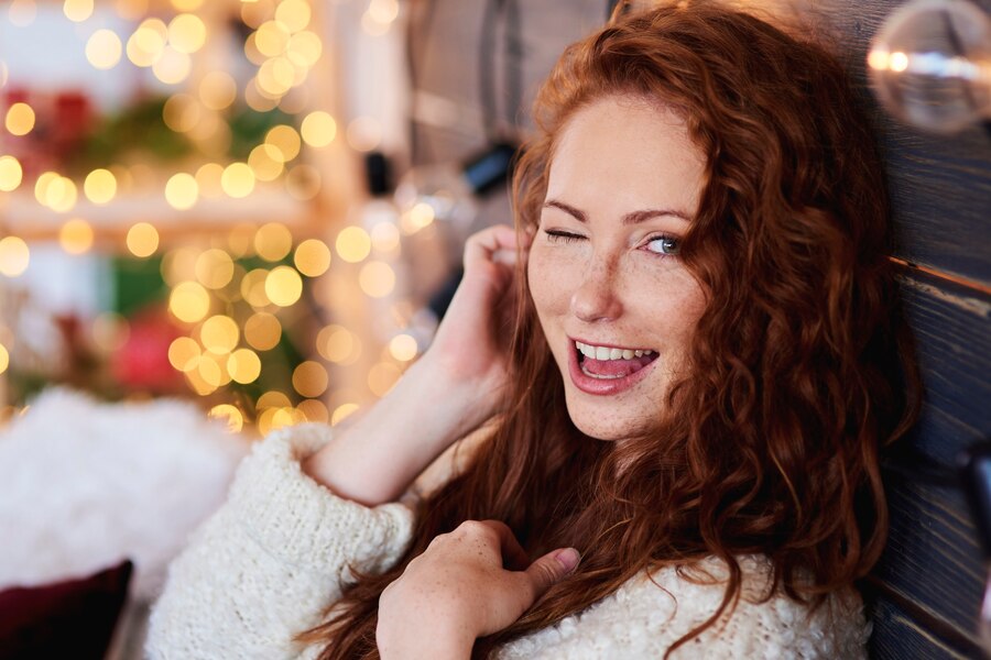 Praznično okrašena dnevna soba, osvetljena z novoletnimi lučkami, ki ustvarjajo toplo in veselo vzdušje