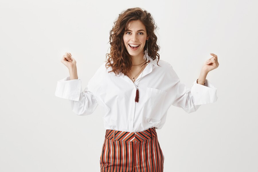 Nasmejana urejena oseba s samozavestno držo, simbolizira notranjo moč, samozavest in osebno rast.